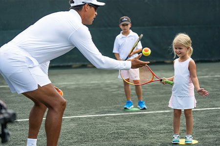 Tennis Instruction tennis instructor with kid at orchid island